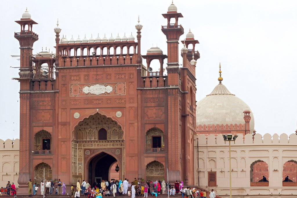 Tourists arrive to the front entrance of historical Badshahi Mosque